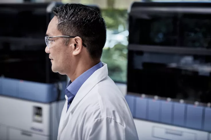 Sideway view of technician in lab setting with medical systems